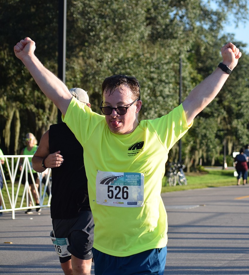 Sarasota resident Joshua Bagal celebrates as he crosses the finish line of the Fort Hamer Bridge Run.