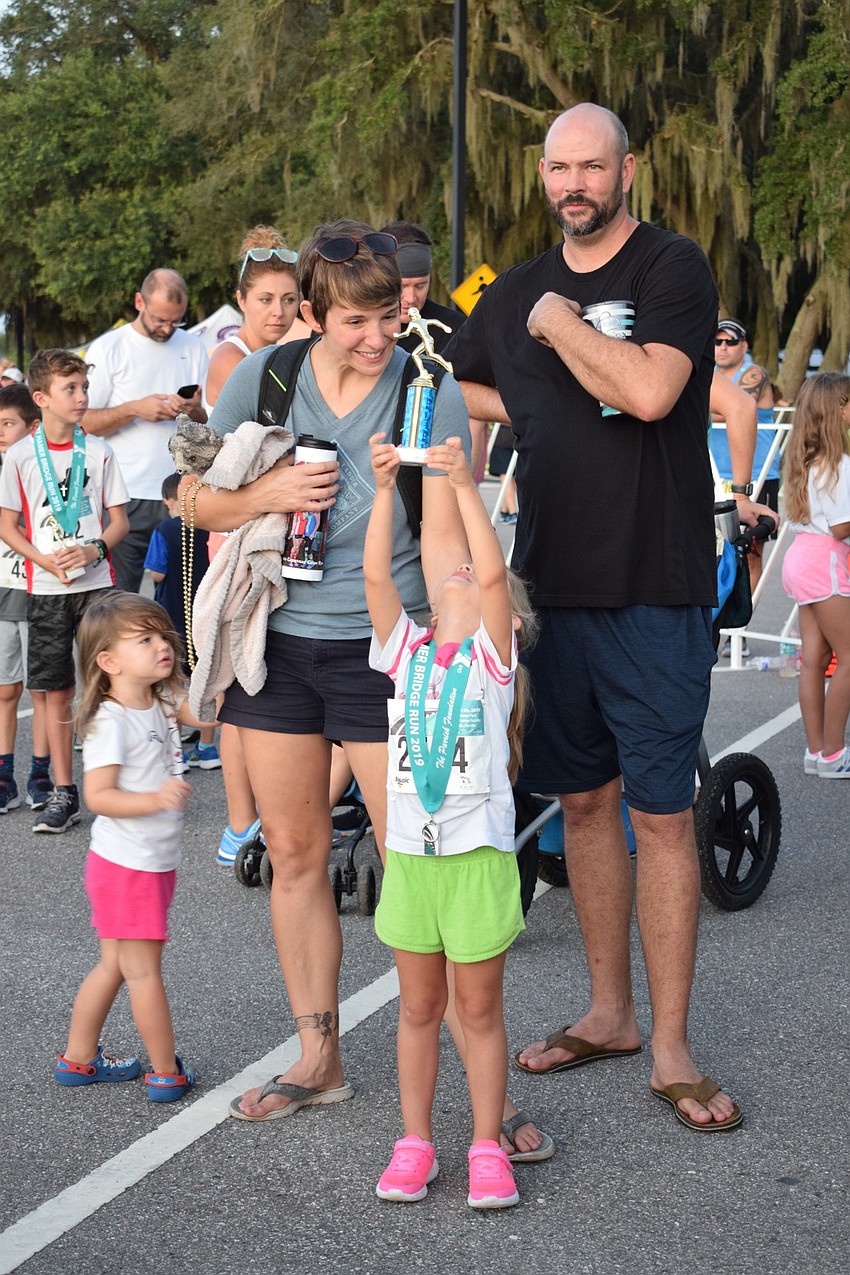 Parrish resident Brooke Kleppe, 4, front, holds up her trophy she received from placing in a kids race as she's surrounded by her sister, Alexis, 2, and parents Sheryl and Blake.