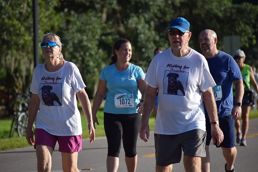 Parrish residents Linda Young and her husband David Clark walk in the Fort Hamer Bridge Run 5K wearing shirts honoring their dog Peaches. Peaches died of cancer at 5 1/2 years old.
