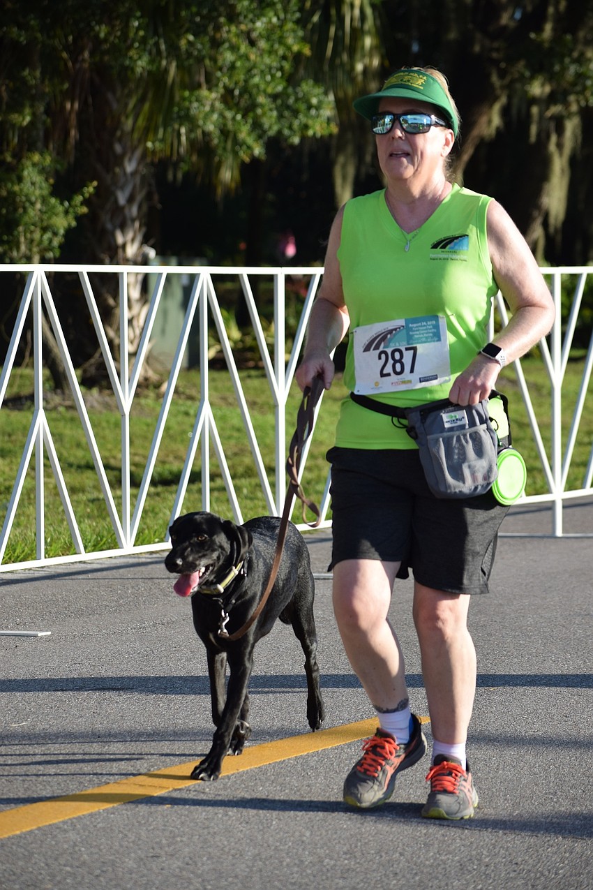 Lakewood Ranch resident Jeannine Walter runs with her 7-month-old dog Jasper during the Fort Hamer Bridge Run. The run was an opportunity for Jasper to get acclimated to large crowds.
