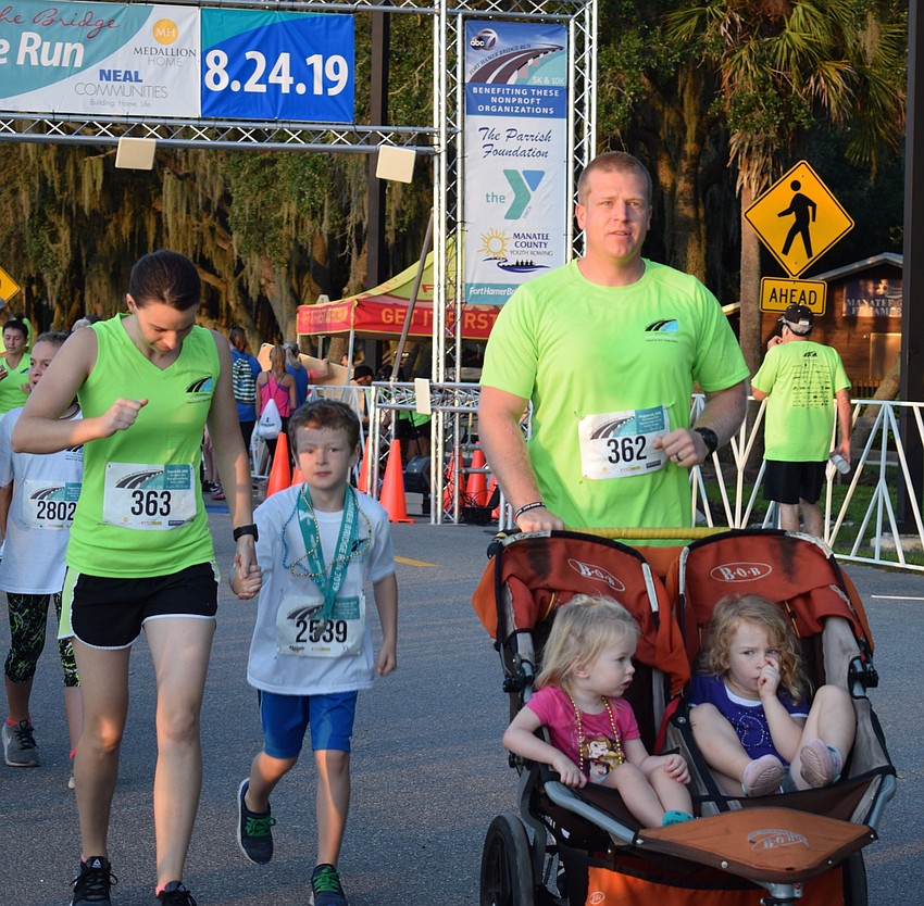 Parrish resident Jessianne Baird, left, starts the Fort Hamer Bridge Run with her family. She and her son Tommy, 7, center, husband Skyler, and daughters Maggie, 2, and Zinnia, 4, all stuck together during the run.