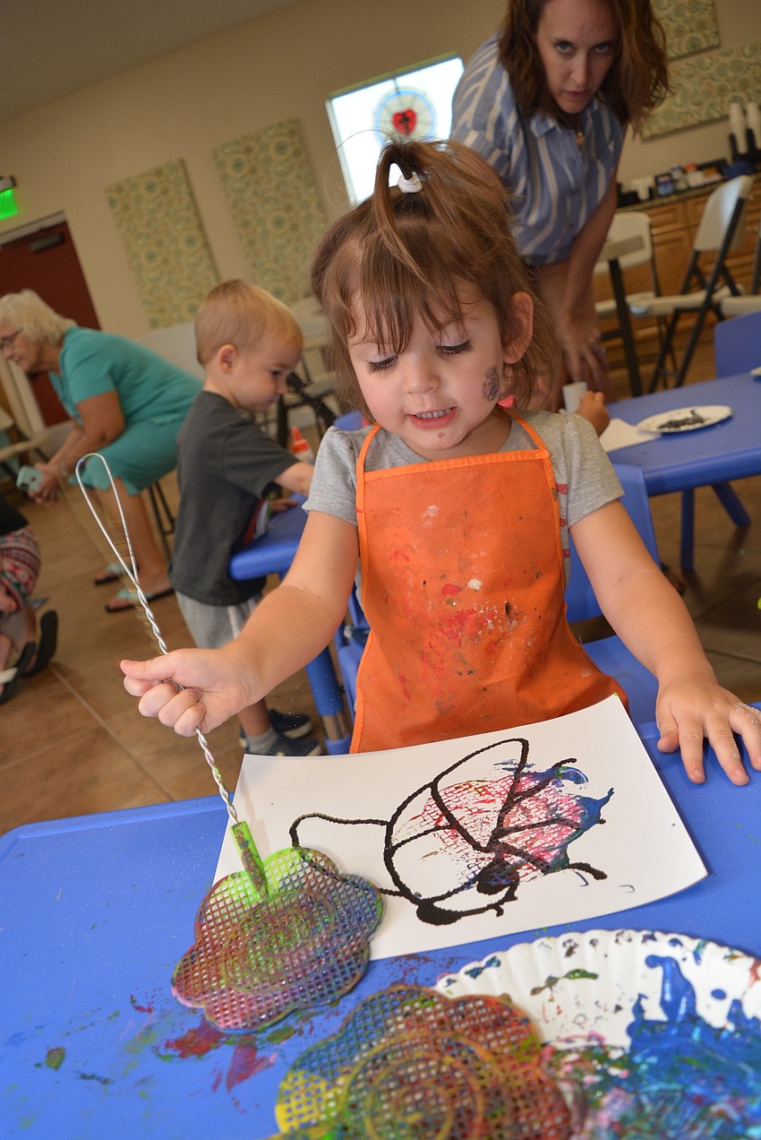 Three-year-old Braden River Lakes resident gets as many colors on her fly swatter as she can before she swats her picture of a fly.