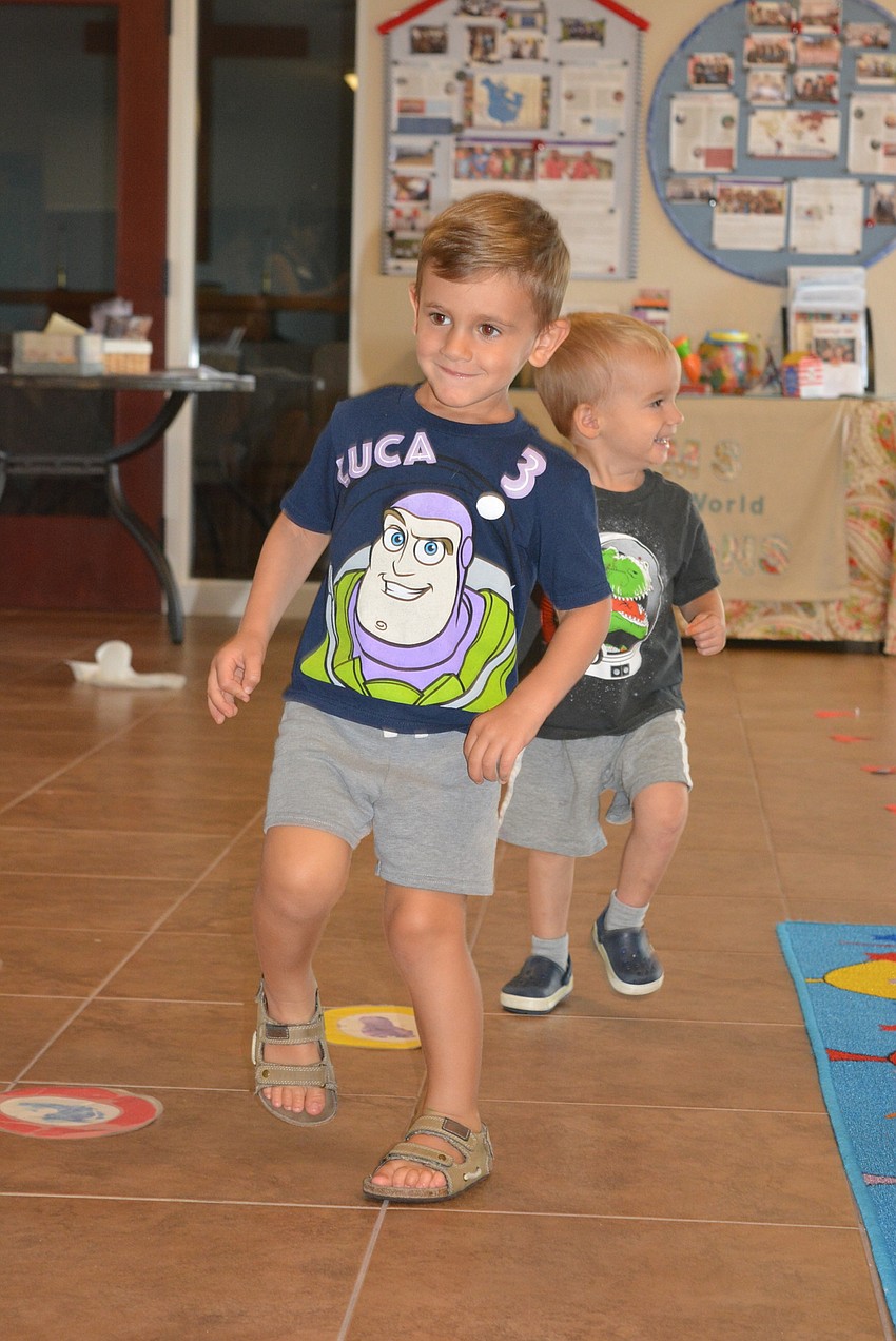 Three-year-old Luca Caiano marches along with other children to 