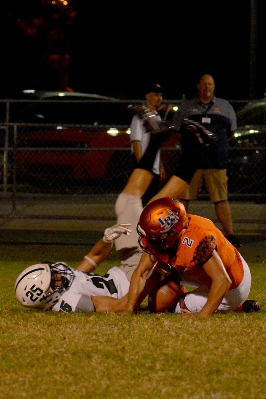 Lakewood Ranch senior Jake Zapatha tackles the Lemon Bay punter after a fumbled snap.