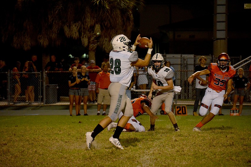 Lakewood Ranch running back Josiah Lozada catches a pitch from quarterback Jimmy Kelly. Lozada led the Mustangs with 30 rushing yards.
