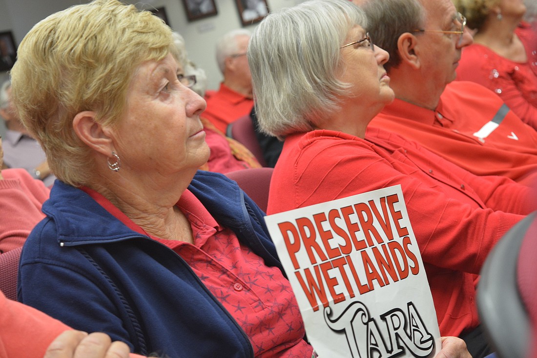 Tara Golf and Country Club resident holds a sign to protest the proposed settlement agreement at a public hearing on the settlement agreement in March 2019. Manatee County commissioners delayed the decision. File photo.