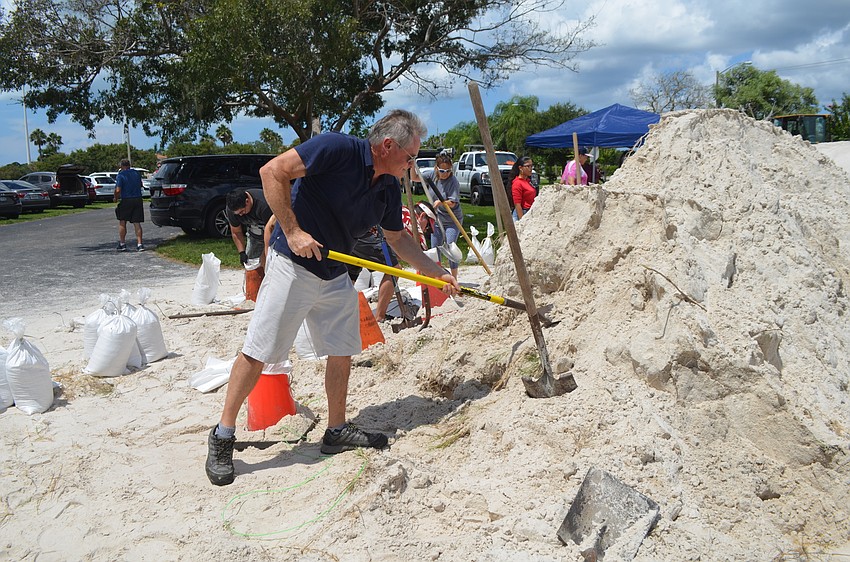 Jim Butler shovels sand into a bag. Butler said his experience during Hurricane Irma motivated him to prepare his house for the forthcoming storm.