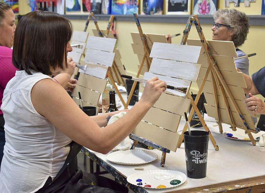 Brooke Boynton begins to add a base coat of white to her board.