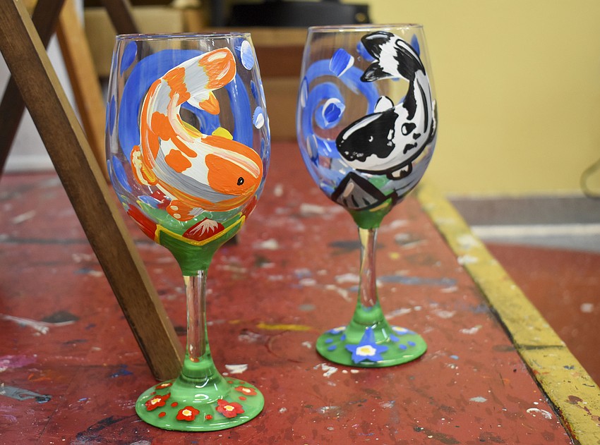 Attendees who chose to paint wine glasses painted orange and black koi fish.