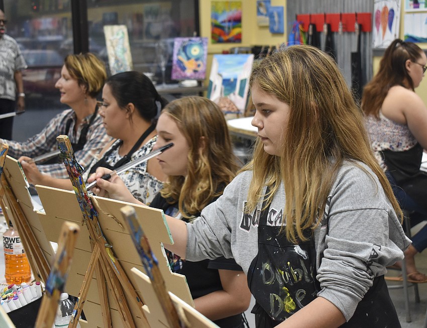 Grace Olesen, 11, stands up to get a better painting angle.