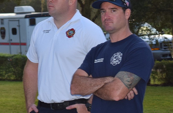 Lt. Brian Carr and firefighter/paramedic Brian Kolesa listen to a briefing Monday morning before heading out to the Orange County Convention Center.