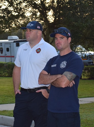 Lt. Brian Carr and firefighter/paramedic Brian Kolesa listen to a briefing Monday morning before heading out to the Orange County Convention Center.