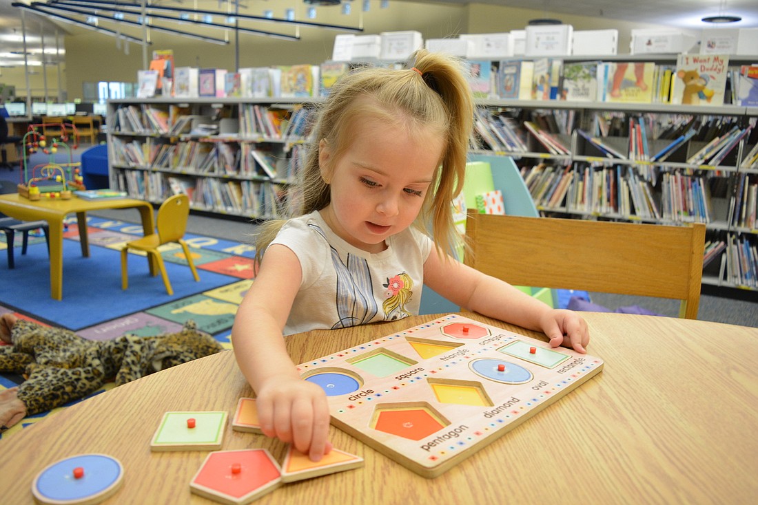 Mill Creek&#39;s Chloe Craciun plays with a puzzle after attending story time at the Braden River Library Sept. 4.