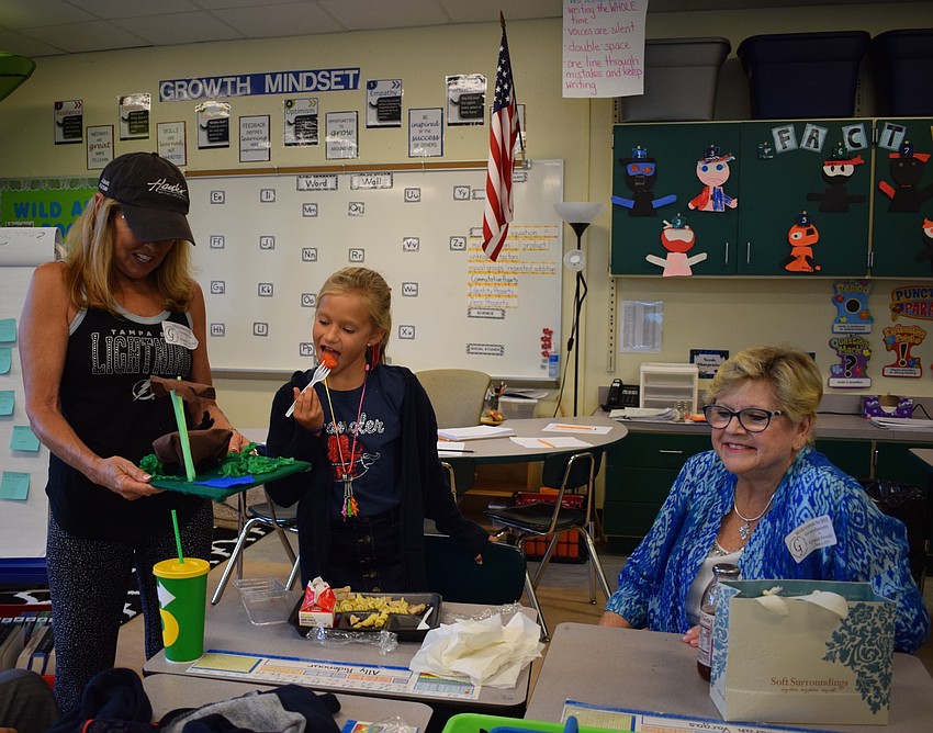 Braden River Elementary School third-grader Ally Ridenour, 8, center, shows some of her artwork to grandmothers Betsy Ridenour, left, and Ginny Sellars, right.