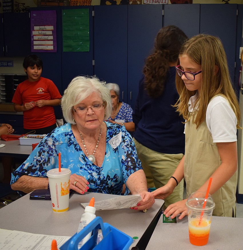 Braden River Elementary School fifth-grader Bayleigh Wilkins, 10, right, shows her grandmother Ina Woody, left, one of her class assignments.