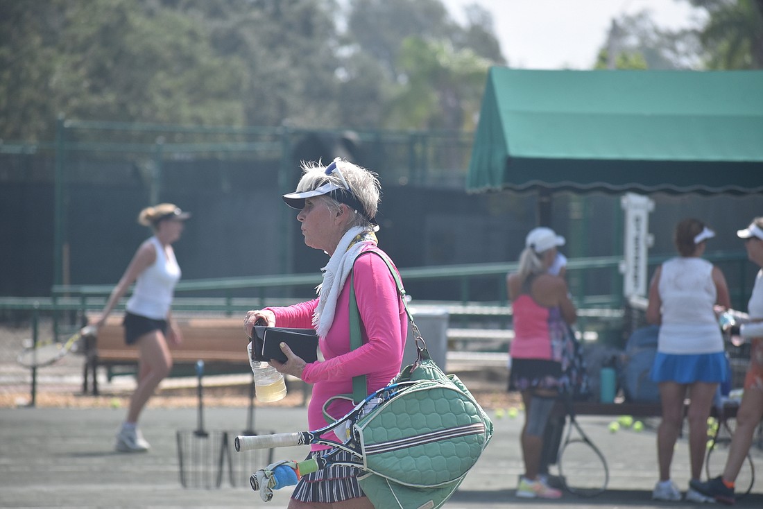 Draped in a cold towel and toting her water bottle, Sandy Schonhoff heads off the court.