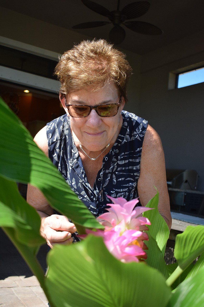Eileen Amesbury admires some of the plants growing in Carolyn Lowry-Nation's lanai.