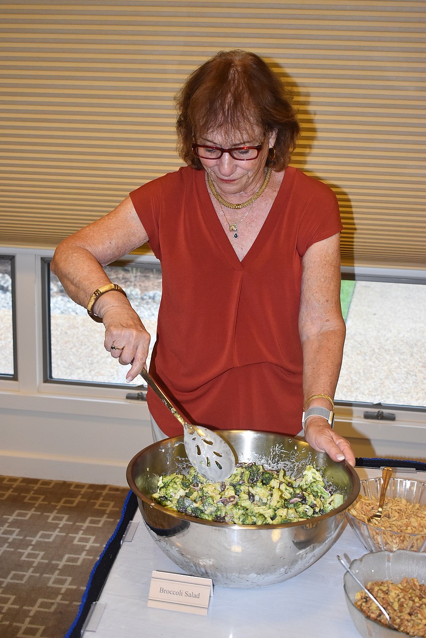 Robin Green finishes the broccoli salad.
