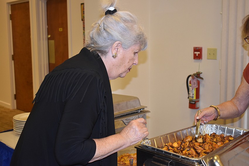Sylvia Pastor inspects the food.