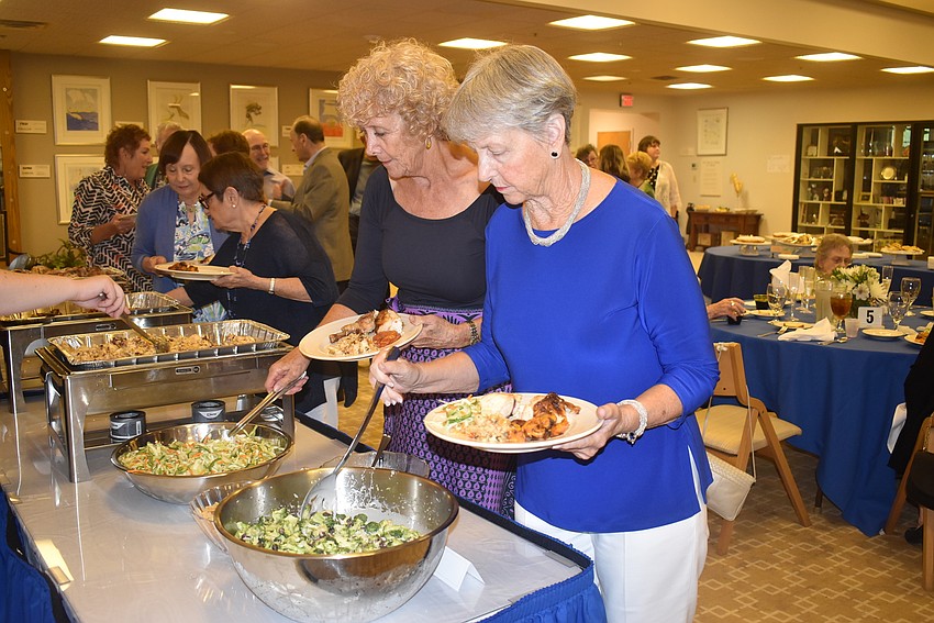 Suzanne Schuster and Ruthie Maass fill their plates.