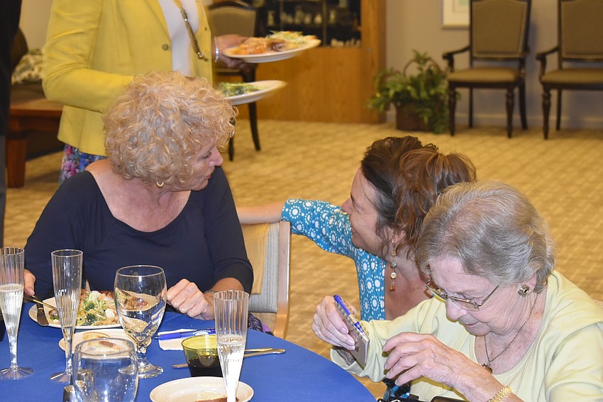 Suzanne Schuster and Lisa Mirman chat tableside.
