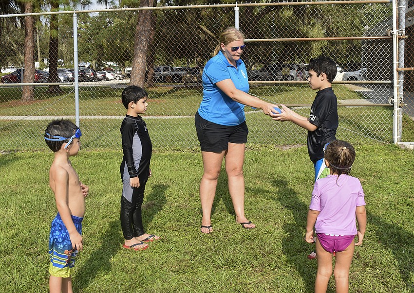 Emily Randell, Arlington Park supervisor of recreation facilities, passes out water balloons as she explains the rules to the kids.