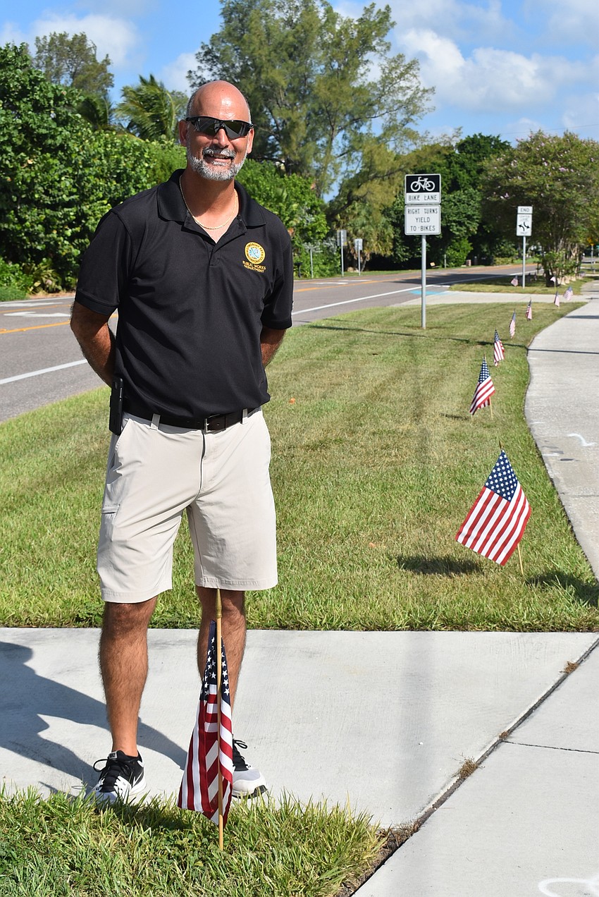 Mark Richardson stands near the flags.