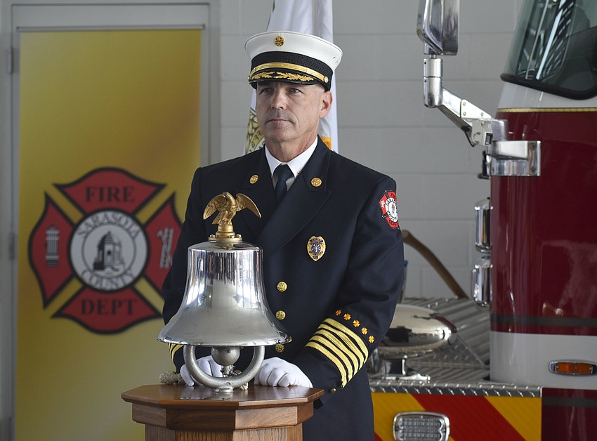 Fire Chief Michael Regnier rings the bell to announce the Fire Department's moment of silence.