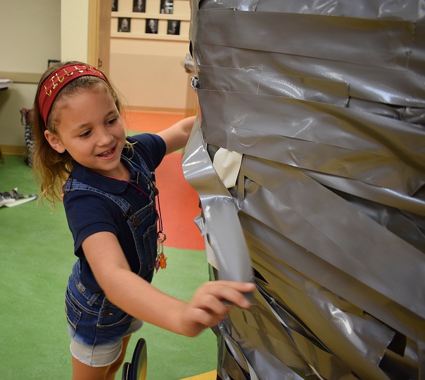 Braden River Elementary School third-grader Lillian Chandler, 8, places a piece of tape onto Assistant Principal Krista Francies.