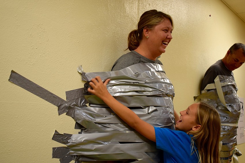 Braden River Elementary School fourth-grader Kylee Francies, 9, right, tapes her mom, Assistant Principal Krista Francies, to a wall. Kylee Francies said it was 