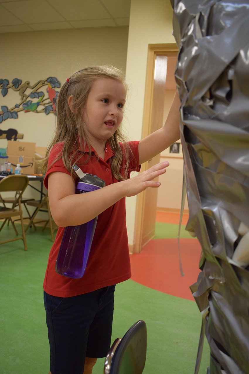 Braden River Elementary School first-grader Faith Dawson, 6, attaches tape to Assistant Principal Krista Francies.