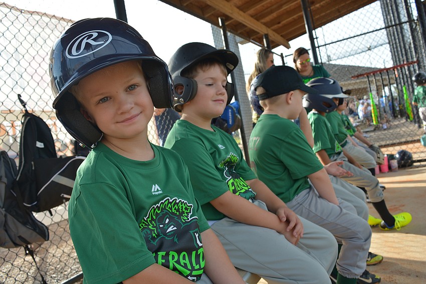 Four-year-old Tristan Brown (with Ben Whipple behind), waits for his turn to bat during the first inning.