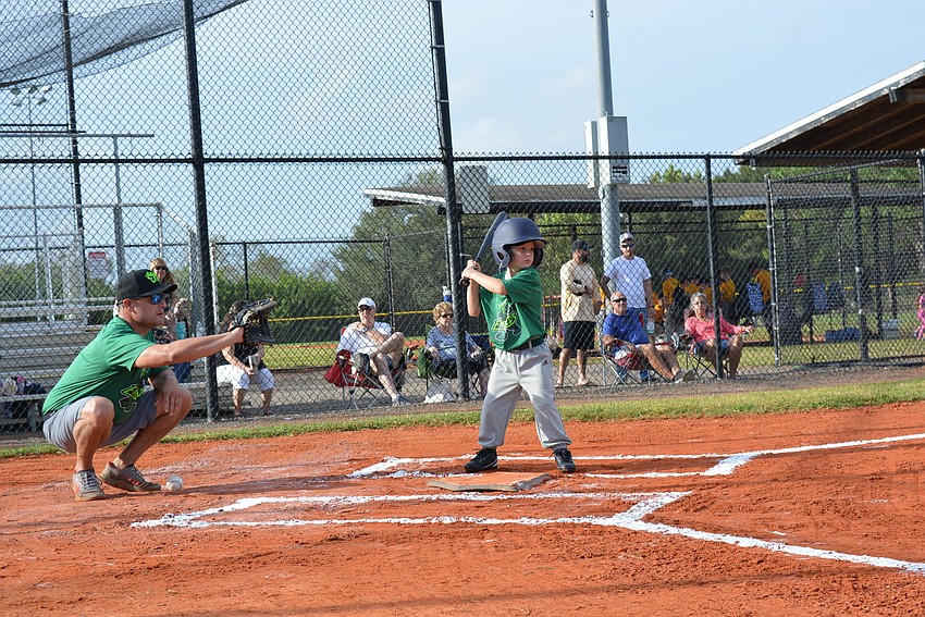 Dan Drohan catches as Gavin Young, 4, bats for the first time of the season. Young makes it to first base.