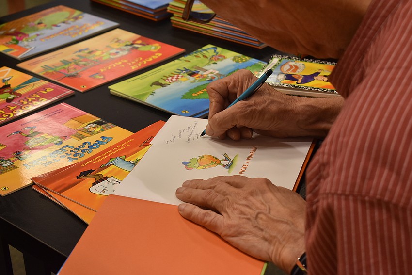 Frank Remkiewicz signs one of the Froggy books.