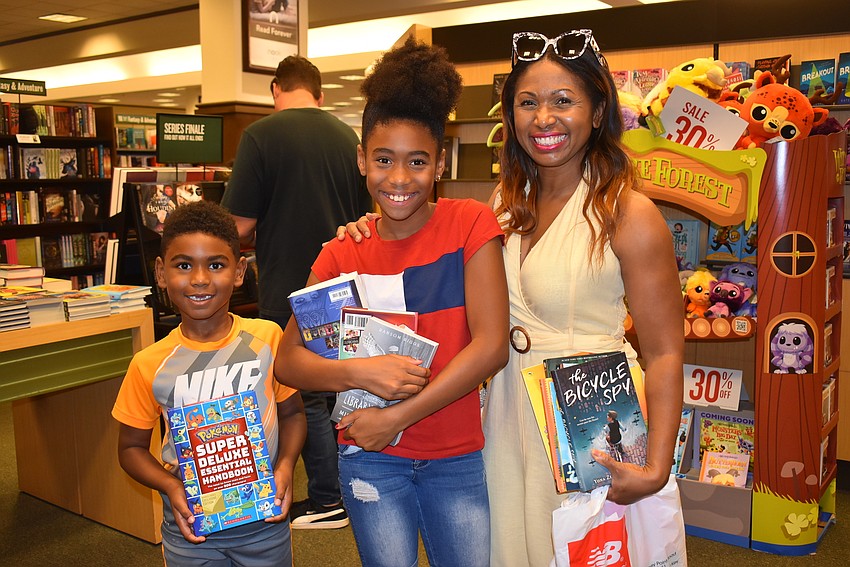 Louie, Elina and Rose Goncalves with their stash of new books.