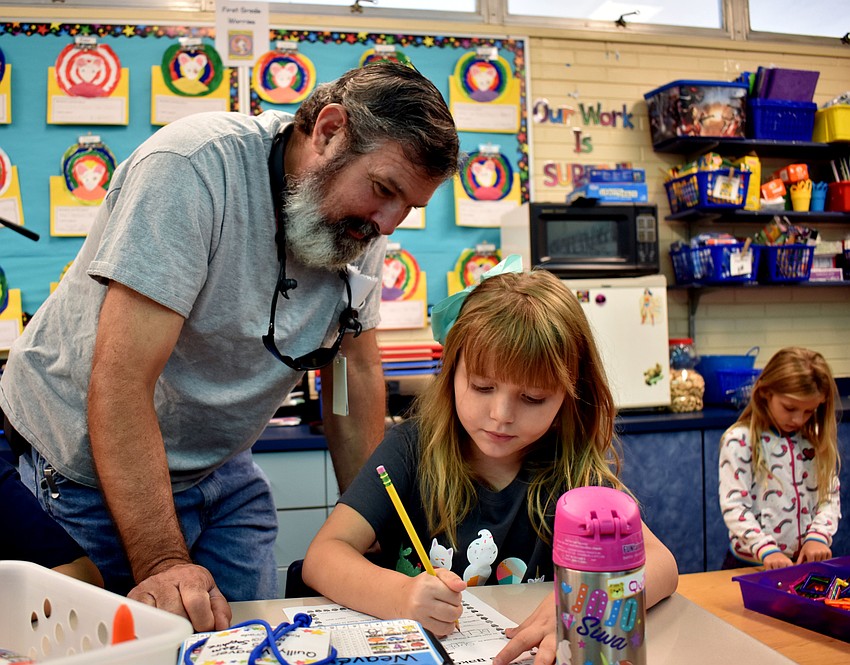 Curt Weaver helps Quilly Weaver with a vocabulary worksheet.