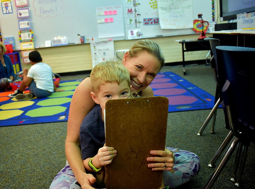 Max Tennimon hides as his mom Megan laughs.