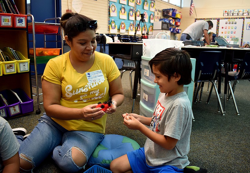 Erika Salas helps  Yemil Zamarron with his creation.