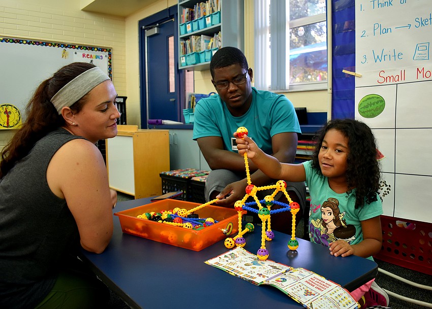 Renee and Michael Celius watch their daughter Mikayla build.