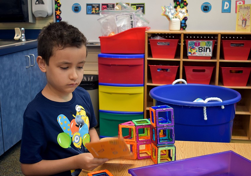 Richie Rodriguez multitasks as he reads and builds.
