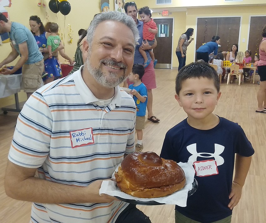 Temple Emanu-El Associate Rabbi Michael Shefrin shares some round challah with Abner Beck.
