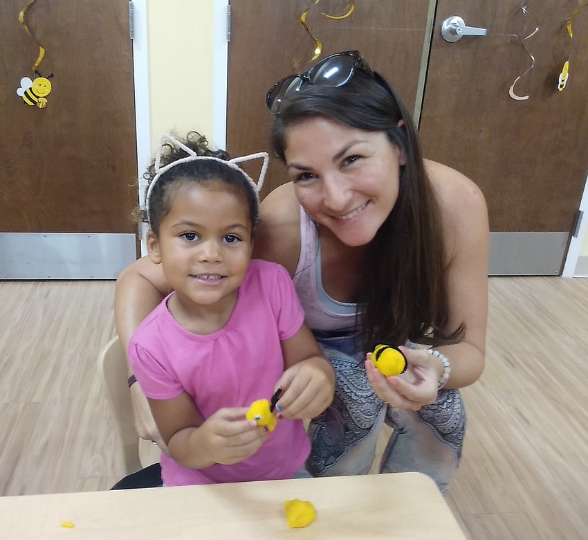 Pamela Lasko helps her daughter Eliana make a clay honeybee.