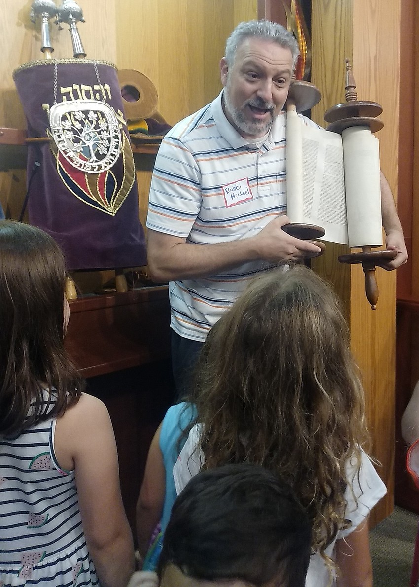 Temple Emanu-El Associate Rabbi Michael Shefrin opens the Holy Ark to show children the sacred Torah scroll.