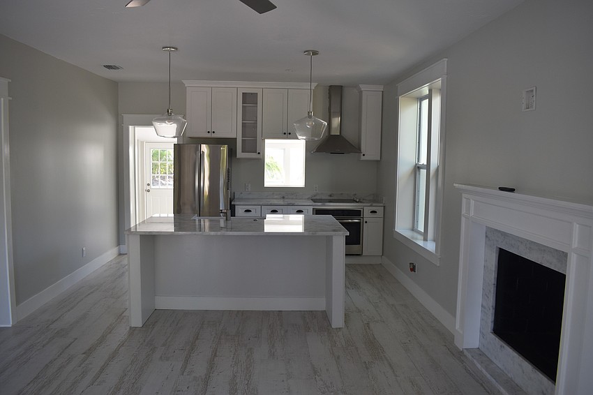 The first room when you walk in includes a kitchen and a fireplace.