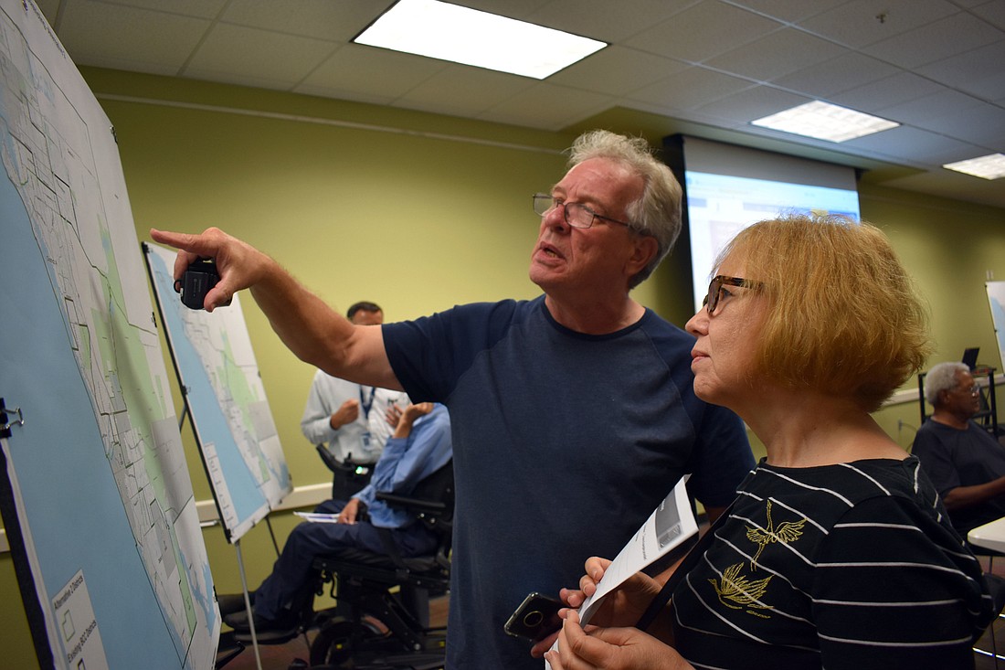 District 2 resident Tom Matrullo and District 1 resident Glenna Blomquist look at maps to determine how their districts would be affected.