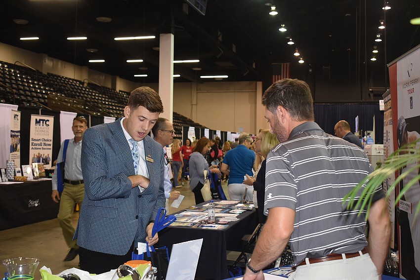 Job Gatchell tries to guess the amount of golf tees in a jar while Matt Kies of the LECOM Suncoast Classic watches.