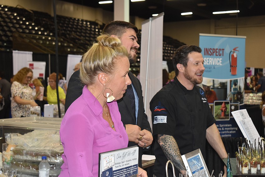 Chart House employees Kristina Nonnemacher, Chris Luthi and Patrick Kenyon serve samples from the table.