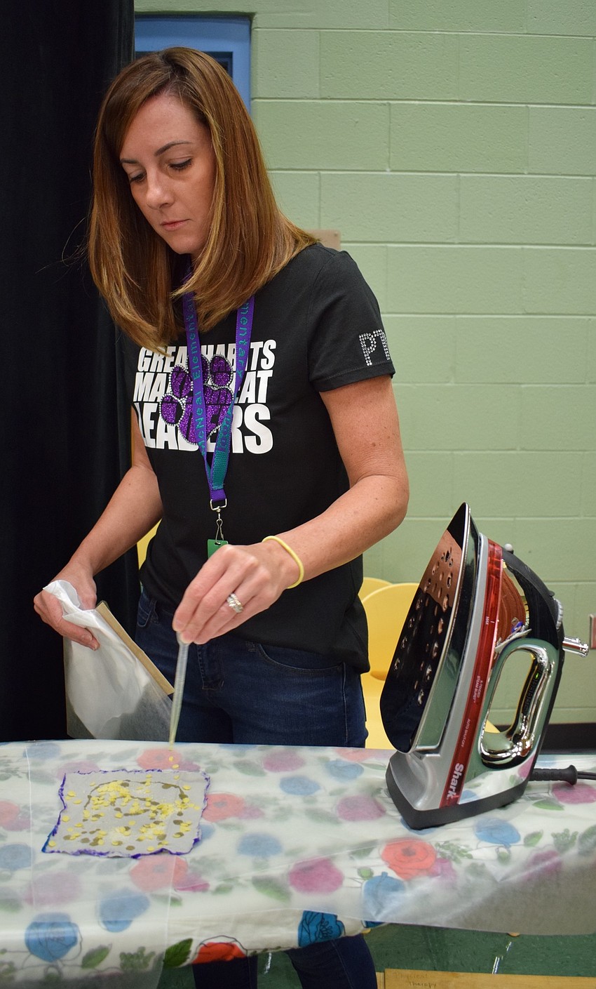 Gilbert W. McNeal Elementary School PTO member Kelly Laning, separates a eco-friendly food storage bag from wax paper. Students made the food storage bags as an alternative to plastic wraps as part of International Peace Day.