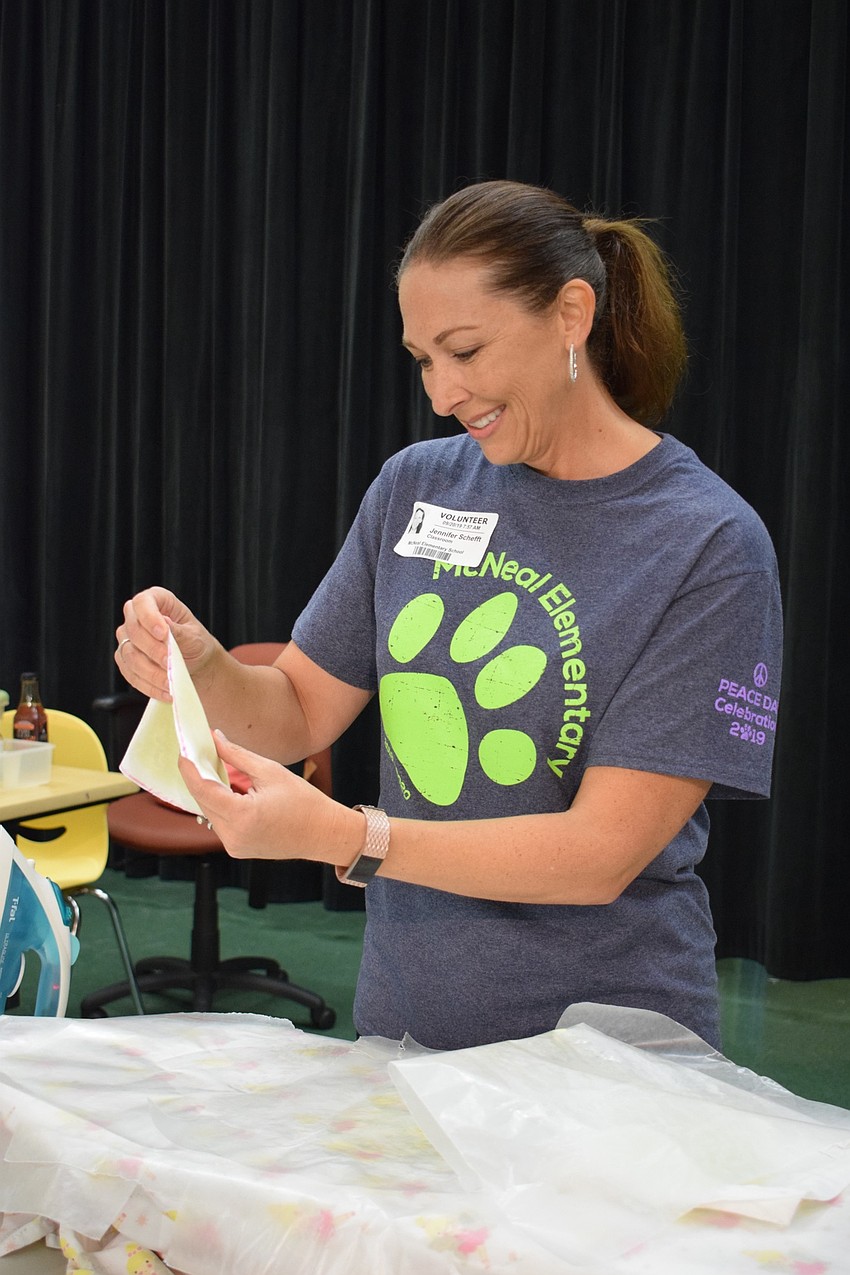 Gilbert W. McNeal Elementary School volunteer Jennifer Schefft waves around eco-friendly food storage a student made to cool it down after using an iron to create it.