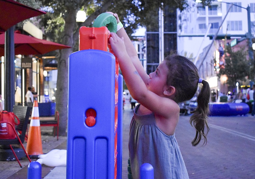 Everly Makmanivorg, 3, plays giant Connect Four.